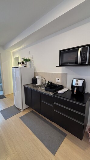 A modern kitchen with a built-in microwave, a refrigerator, and a coffee machine. - Pateo Rio Stay, Porto Maravilha, Rio de Janeiro. (Rio de Janeiro)
