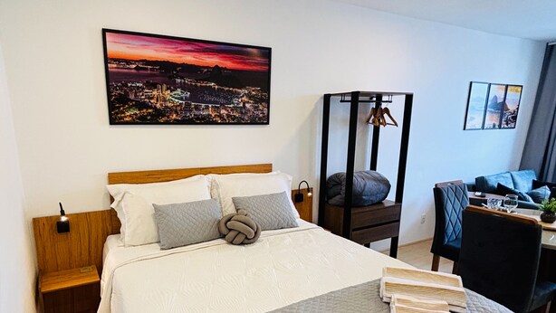 A hotel room with a large bed, a desk, and a chair. There is a painting on the wall and a window with curtains. - Pateo Rio Stay, Porto Maravilha, Rio de Janeiro. (Rio de Janeiro)