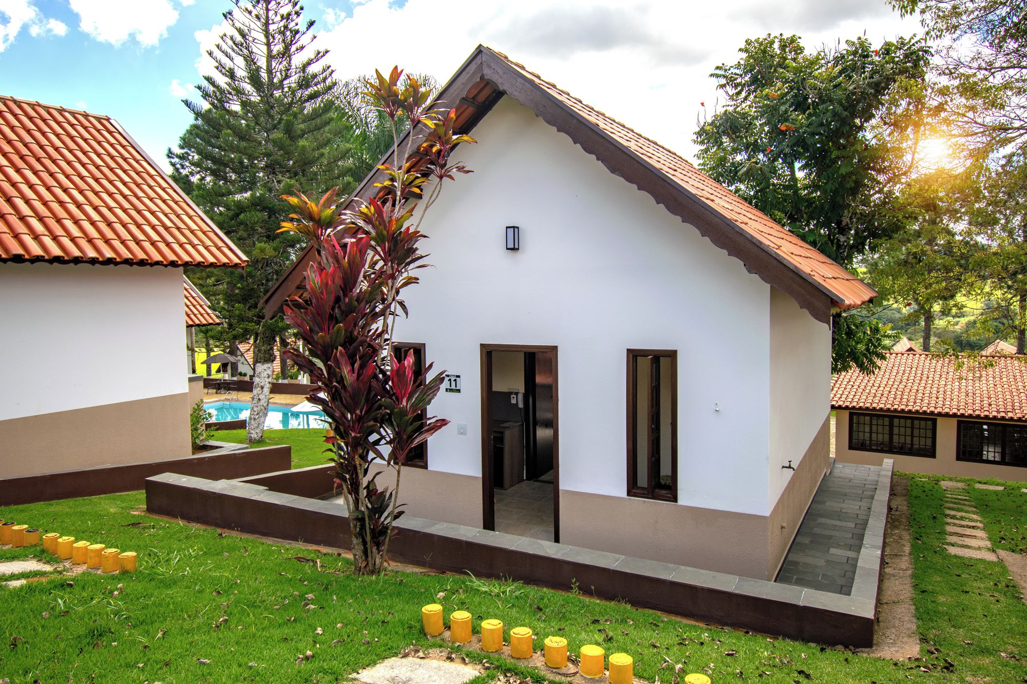 A small building with a sloped roof, a door, and a window.