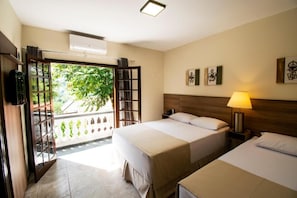 A hotel room with two beds, a balcony, and artwork on the walls. - Hotel Dona Paschoalina (Socorro)
