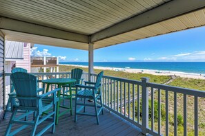A covered outdoor area with a view of the beach, featuring a table and chairs. - 🌊La Mer | 3Br Oceanfront Condo with Shared Beach Walkover🧜‍♀️ (Carolina Beach)