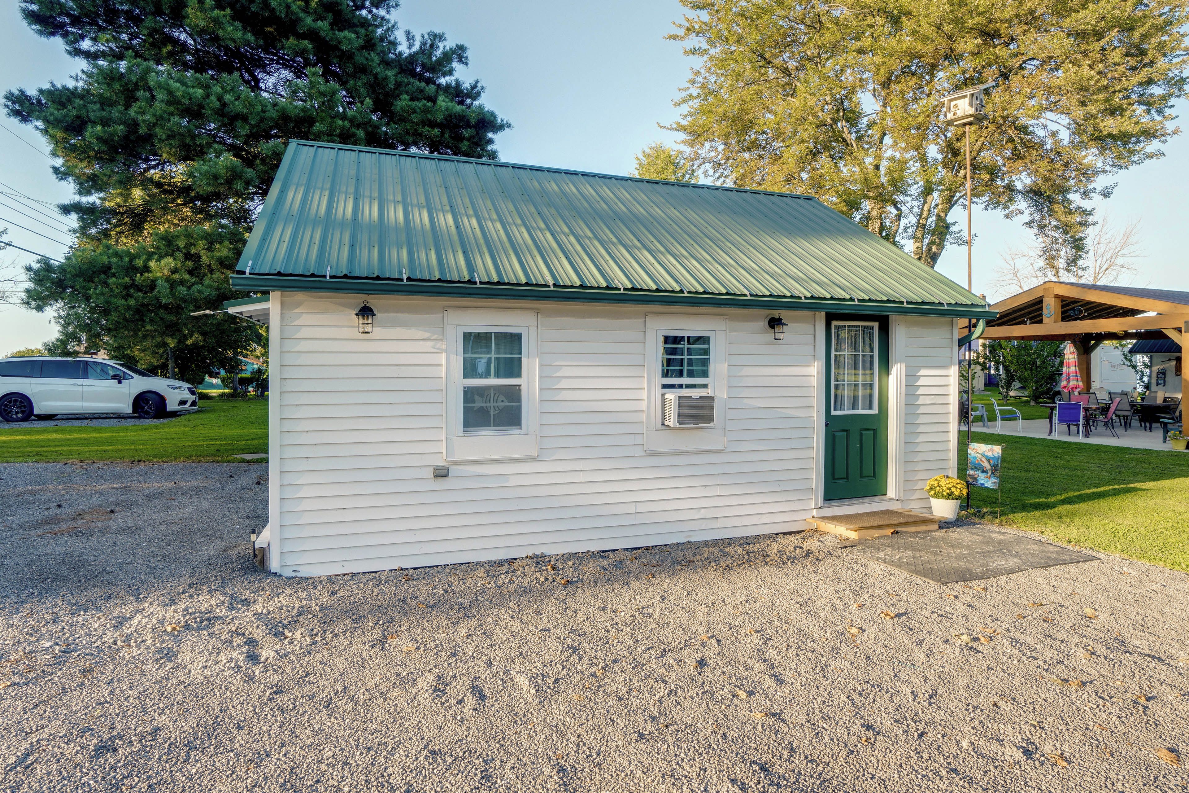 A small, single-story building with a green metal roof, a front door, and a small window.
