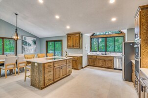 Una cocina moderna con armarios de madera, una isla central y ventanas amplias.
