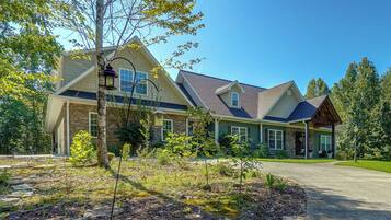 A two-story house with a stone facade, a covered porch, and a well-maintained garden.