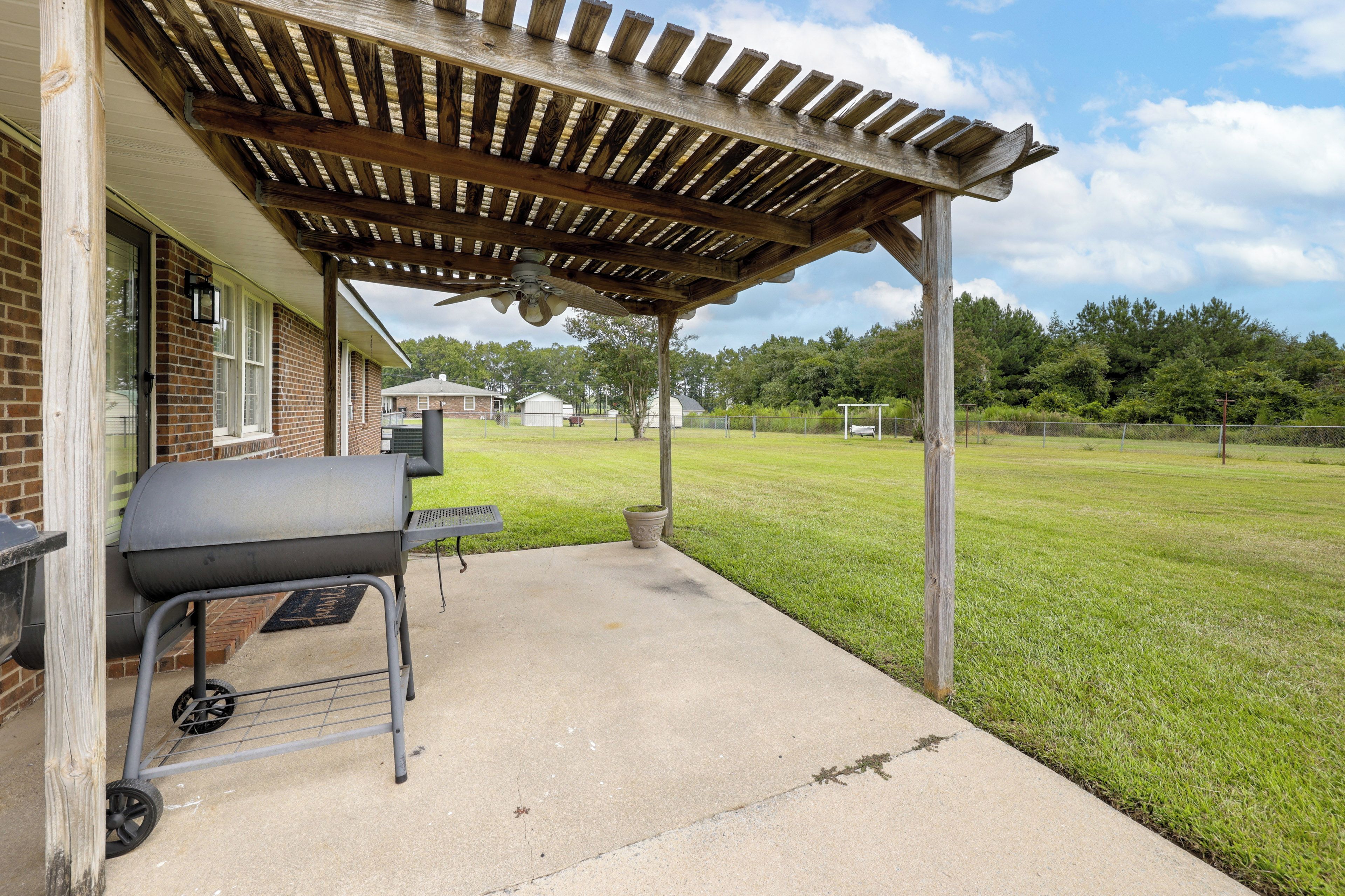 Un patio couvert équipé d’un barbecue et doté d’un sol en béton.