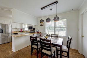 A modern kitchen with a central island, stainless steel appliances, and pendant lighting.