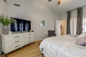 Un dormitorio con una cama grande, un aparador, un televisor de pantalla plana y un espejo.