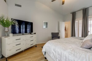 A bedroom with a large bed, a dresser, a flat-screen TV, and a mirror. - Near Golf & Outdoor Fun! West Valley Retreat (Peoria)