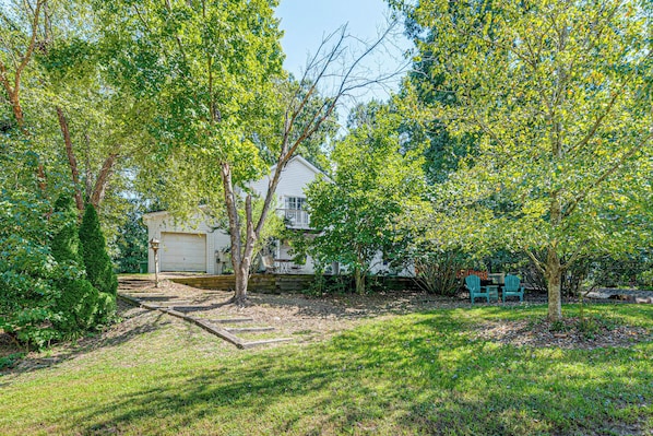 A residential property with a garage, a lawn, and a small patio area with outdoor furniture. - Raleigh-area Farm Stay w/ Pond: Swim, Fish, Relax! (Clayton)