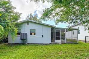 A single-story house with a covered porch, a small attached garage, and a well-maintained lawn. - Yard & Patio! Naples Home By Botanical Garden (Naples)