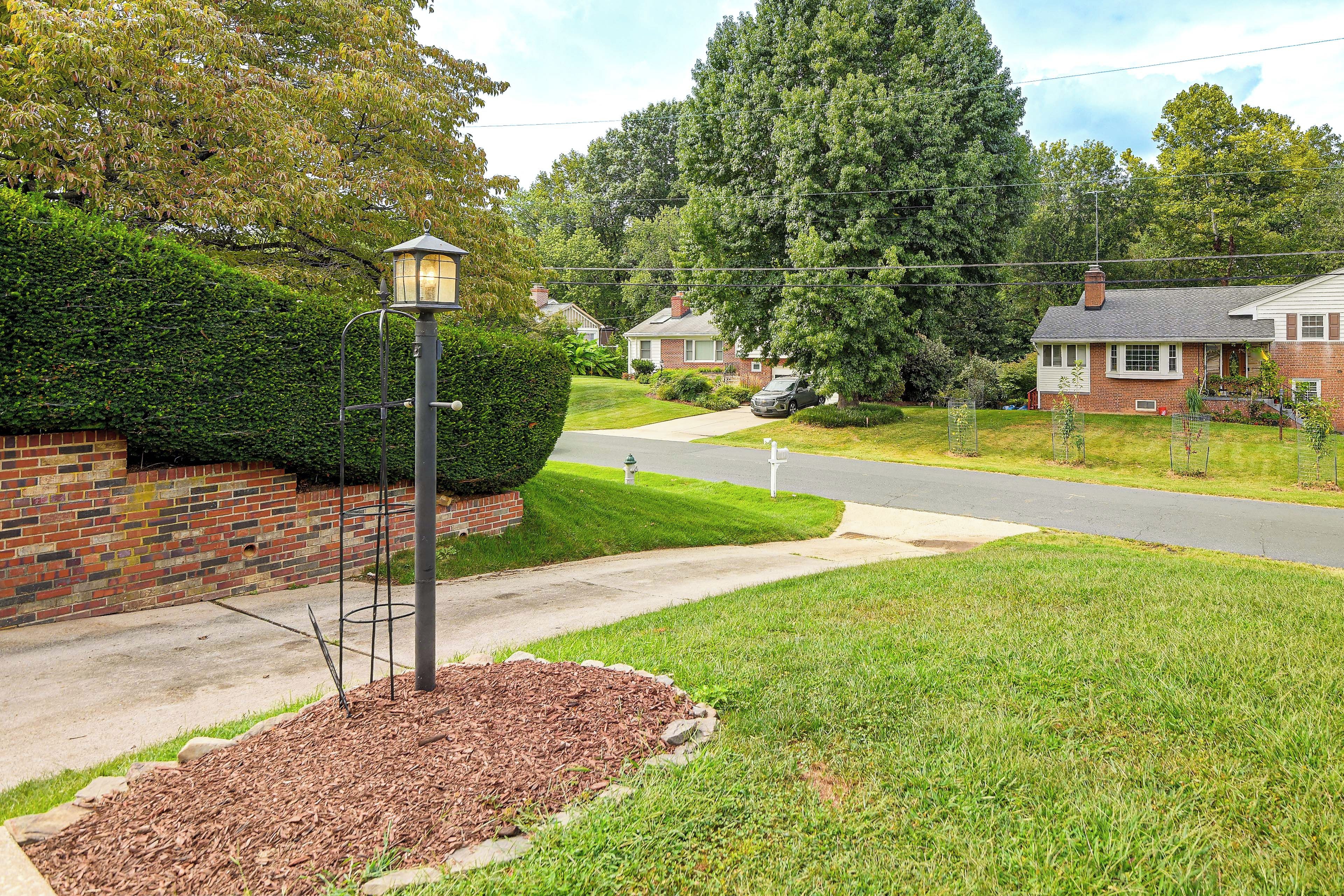 A residential street with houses, a street lamp, and a well-maintained lawn.