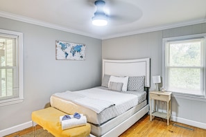 A neatly arranged bedroom with a bed, bedside table, and a world map on the wall.