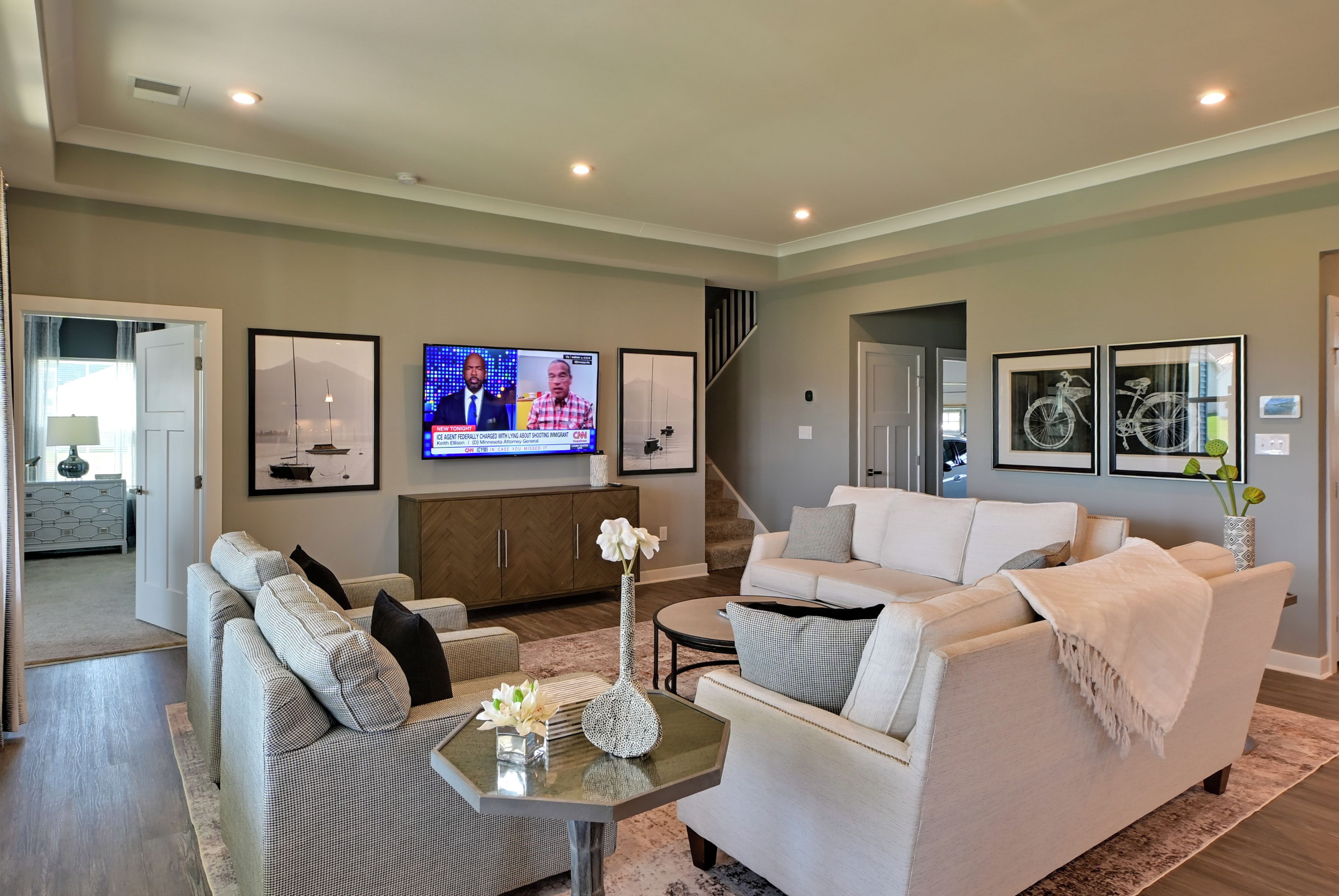 A modern living room with a sofa, a coffee table, and a TV mounted on the wall.