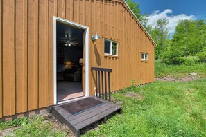 A wooden cabin with a door open, revealing a room with a ceiling fan, a bed, and a window. - Hike, Fish & Unwind! Catskills Studio w/ Mtn Views (Hobart)