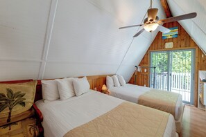 Une chambre avec deux lits, un ventilateur de plafond, une horloge et une fenêtre donnant sur un paysage verdoyant.