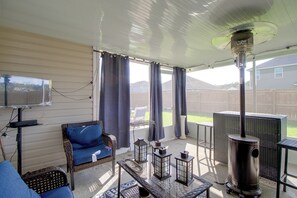 A covered outdoor living area with a sofa, a table, a TV, and a wood-burning stove. - 4 Mi to Fort Stewart: Group Escape w/ Private Yard (Hinesville)