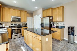 A kitchen with wooden cabinets, stainless steel appliances, and a black granite countertop.