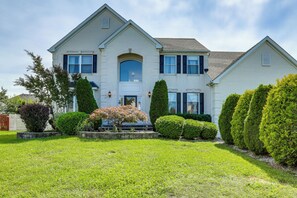 A two-story house with a front entrance, a garage, and a well-maintained lawn.
