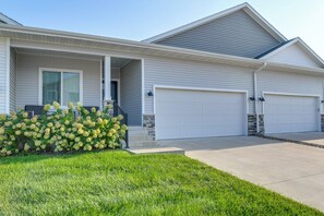 A two-story house with a covered porch, a garage, and a well-maintained lawn.