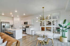 A modern kitchen with white cabinetry, stainless steel appliances, and a central island.