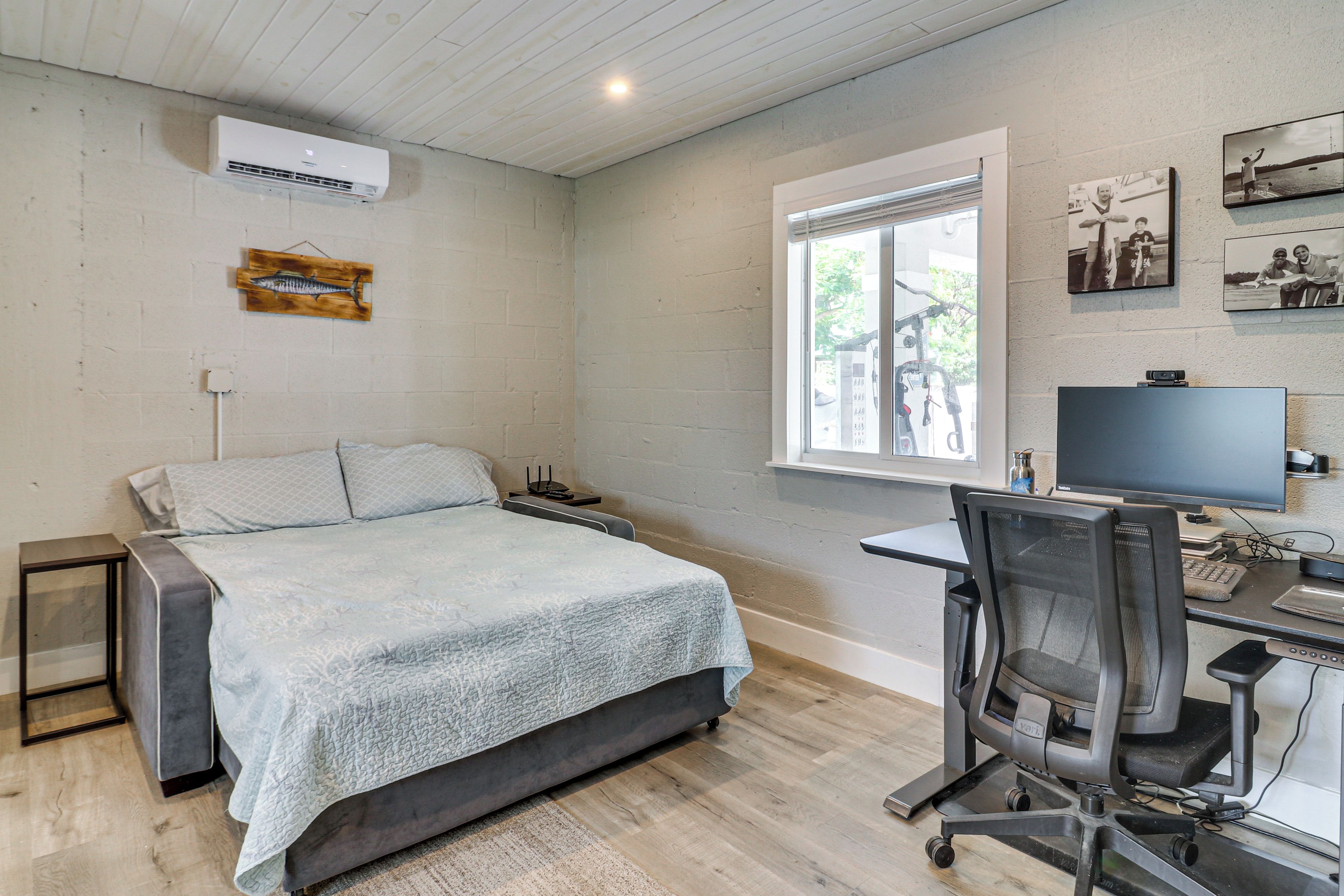 Quarto com uma cama, uma escrivaninha e uma janela.