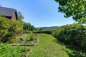 A garden with a wooden structure, a swing set, and a view of mountains. - Hiking Days, Campfire Nights! Hot Springs Hideaway (Hot Springs)