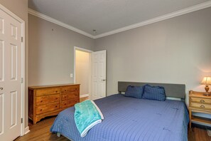 A bedroom with a bed, dresser, nightstand, and a door leading to another room. - Hiking Days, Campfire Nights! Hot Springs Hideaway (Hot Springs)