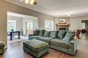 A spacious living room with a sectional sofa, a fireplace, and a dining area with a table and chairs. - Hiking Days, Campfire Nights! Hot Springs Hideaway (Hot Springs)