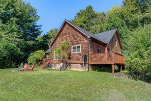 A wooden cabin with a deck, a small porch, and a stone fireplace. - Hiking Days, Campfire Nights! Hot Springs Hideaway (Hot Springs)