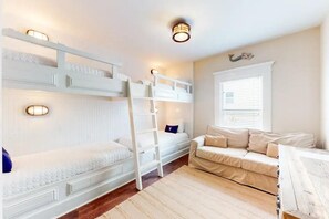 A room with bunk beds, a sofa, and a window with blinds. - Vitamin Sea- VCB (Destin)