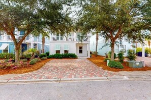 A residential street with a paved driveway leading to a white house with a balcony. - Vitamin Sea- VCB (Destin)