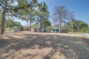 Uma propriedade com várias cabanas, um quintal cercado e céu limpo.