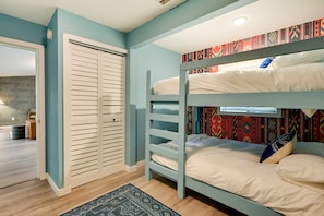 Quarto com beliche, guarda-roupa e tapete, com parede estampada.