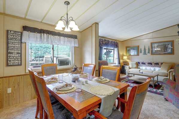 Comedor con una mesa de madera dispuesta para cuatro personas, rodeado de sillas.
