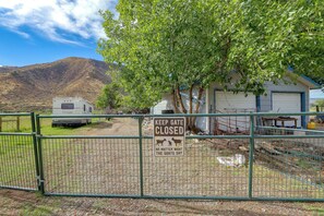 A gated area with a sign indicating the gate is closed, a trailer, and a building with a garage.