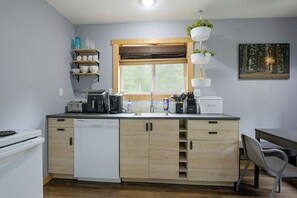 A compact kitchen with a dishwasher, a coffee maker, and a toaster. - Secluded Hayward Cabin With Hot Tub/on Trailhead (Hayward)
