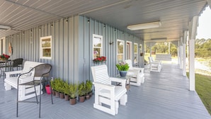 A covered porch with white furniture and potted plants. - Georgia Cabin Escape on 500 Acres (Nashville)