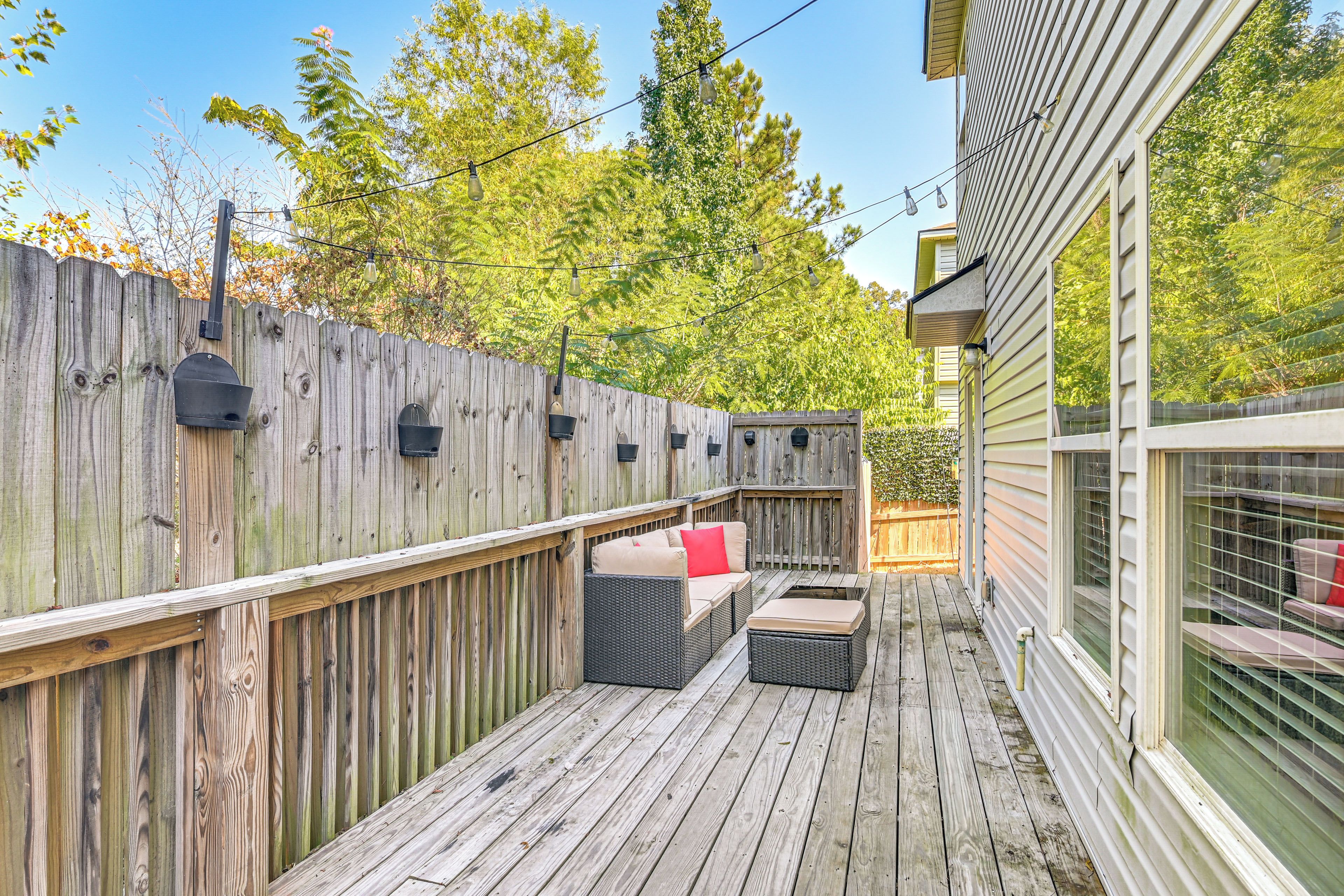 A wooden deck with outdoor furniture, a mailbox, and a house in the background.