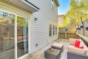 Un patio couvert avec des meubles d’extérieur, une terrasse en bois et une vue sur le jardin arrière.