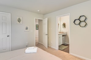 A bedroom with a bed, a door, and a hallway leading to a bathroom. - 'the Haven at Northport' 5 Mi to UA Campus! (Northport)