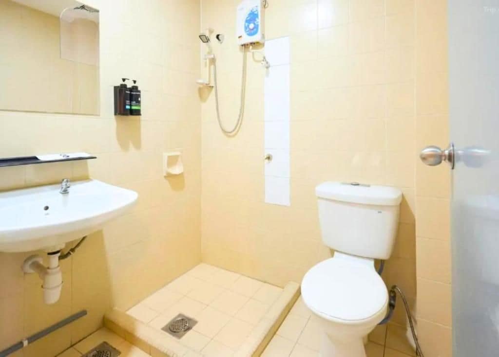 A bathroom with a white sink, toilet, and shower.
