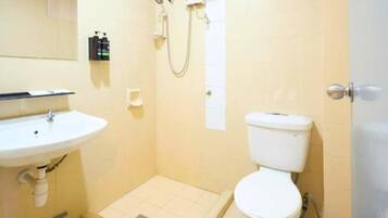 A bathroom with a white sink, toilet, and shower.