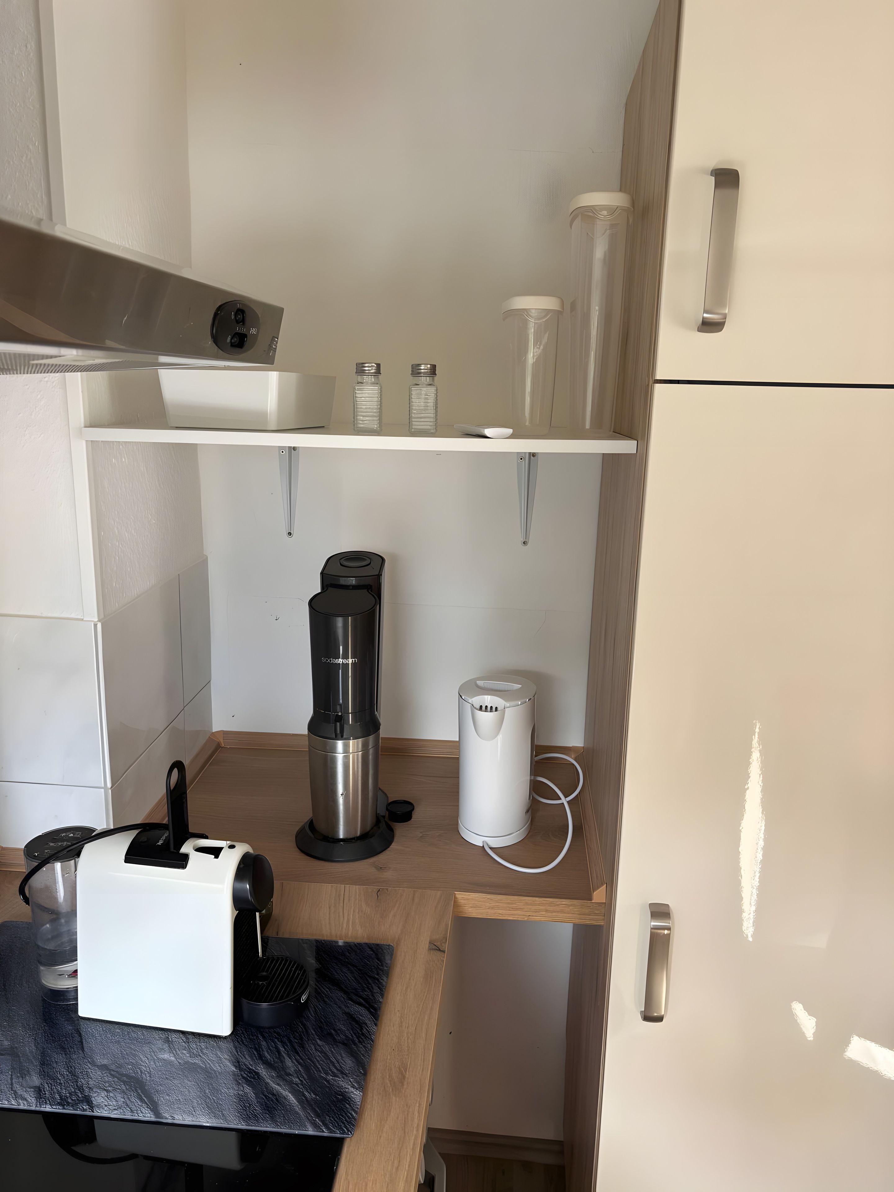 A compact kitchenette with a coffee maker, a blender, and a small refrigerator.