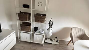 Ein modernes Zimmer mit einer weißen Regaleinheit, einem weißen Tisch, einem weißen Stuhl und einem Holzboden.