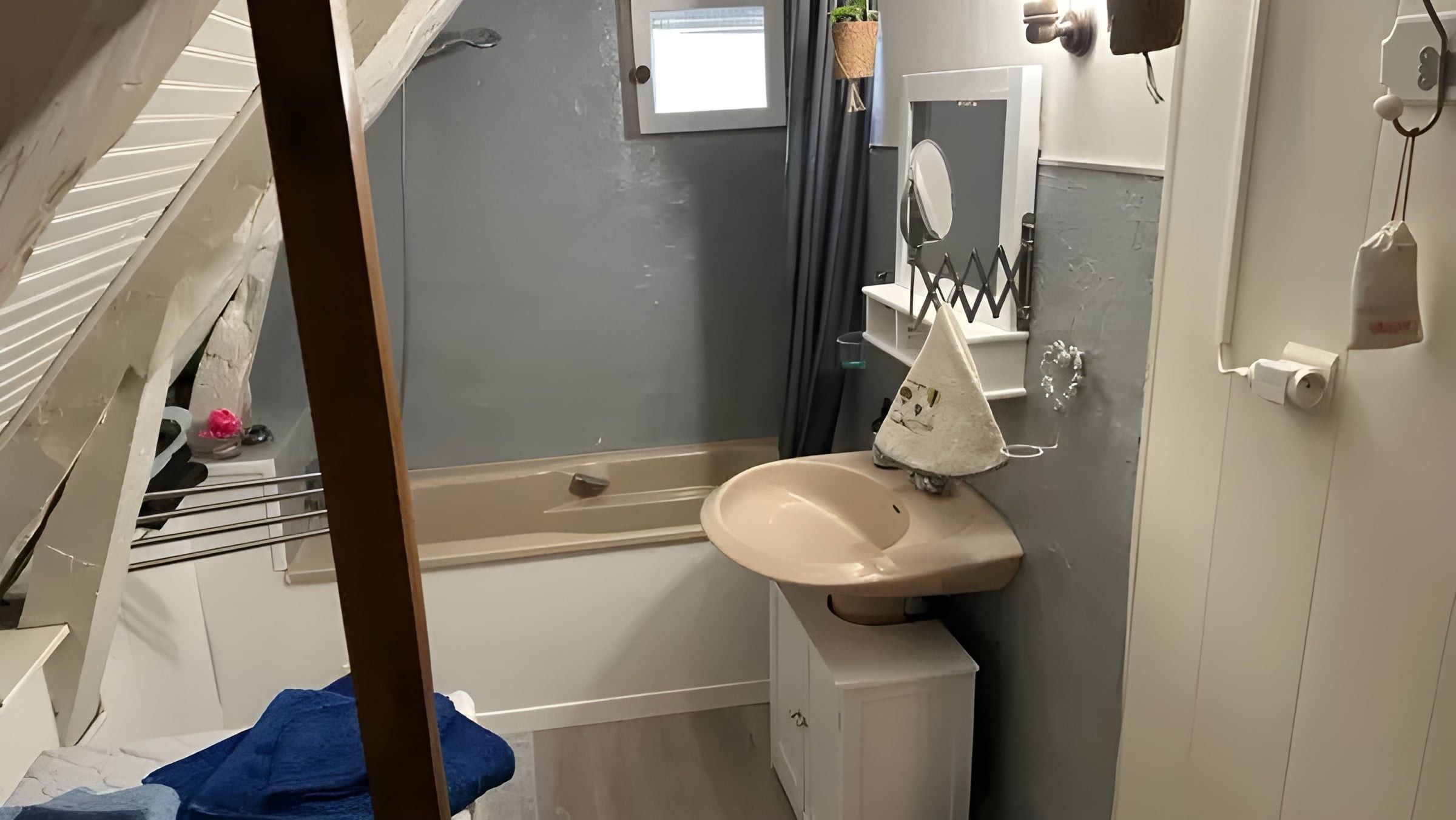 Une petite salle de bain comprenant un lavabo, un miroir et un porte-serviettes.