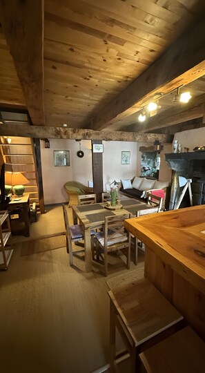 Quarto aconchegante com mobiliário de madeira, uma mesa de jantar e um sofá.