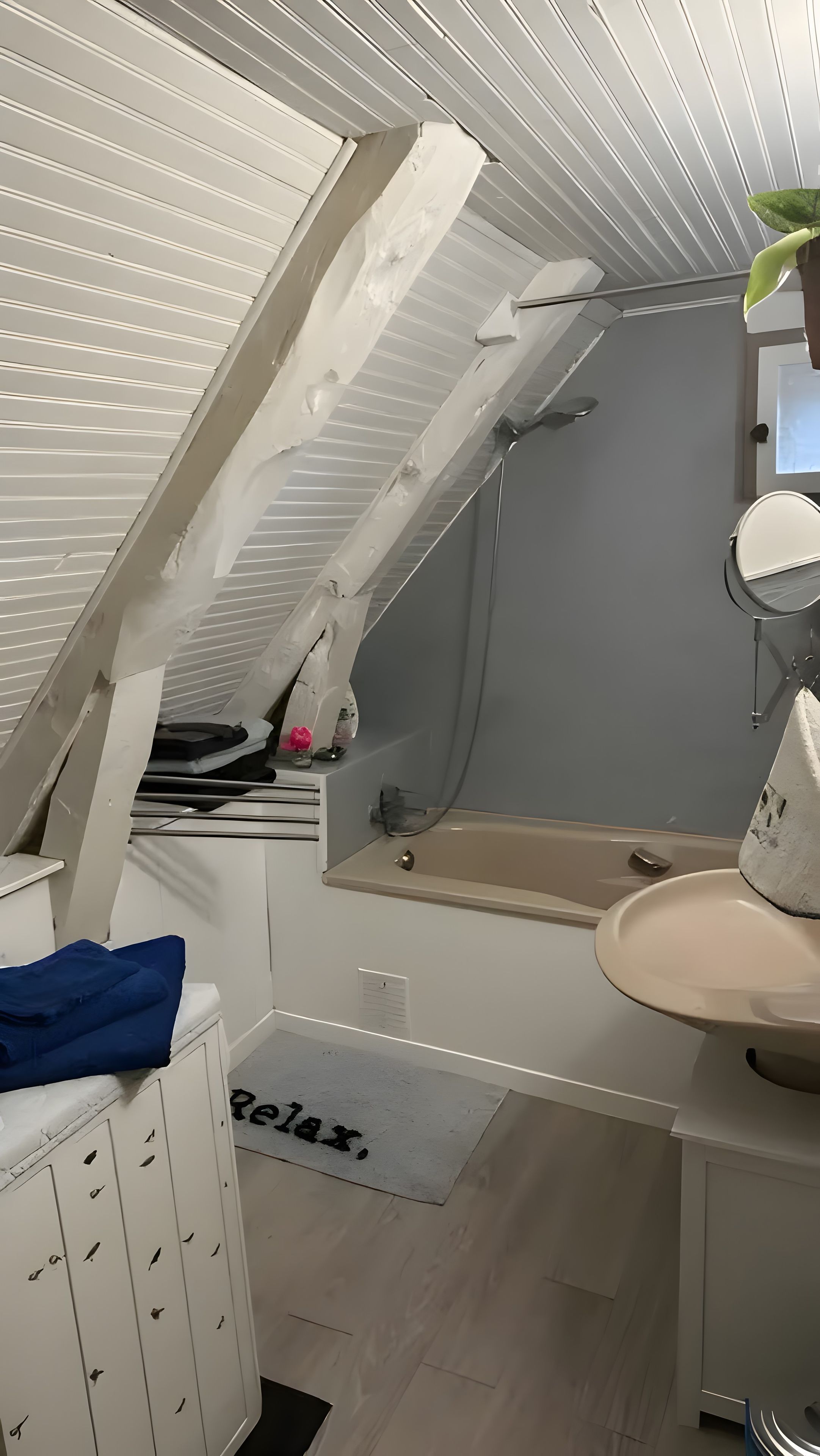 Een moderne badkamer met dakraam, bad en wastafel.