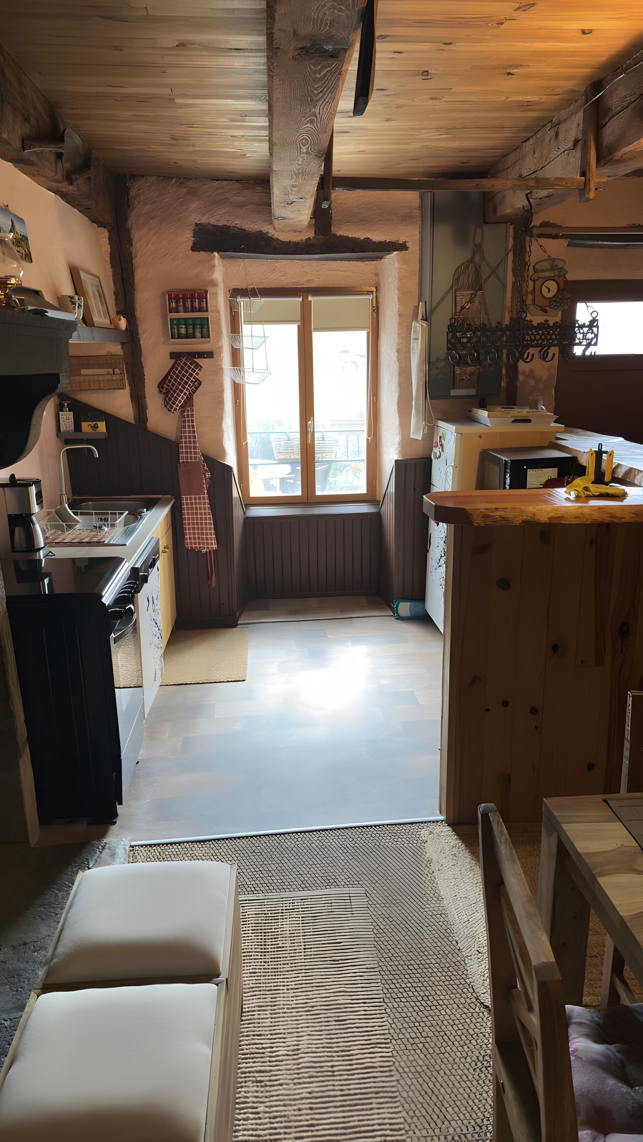 Una cocina acogedora con armarios de madera, una mesa de comedor y vistas a través de una ventana.