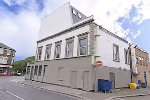 A building with a flat facade, multiple windows, and a door. - Bright 3BR Next to Clapham Junction | 1m to Trains (London)