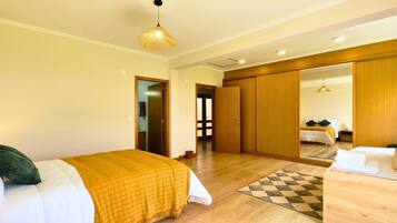 Una habitación de hotel con una cama, una mesita de noche, un espejo y un armario.